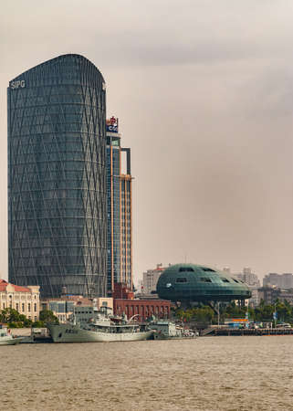 Shanghai, Pudong, Lujiazui, China - May 4, 2010: Closeup of SIPG skyscraper along Huanpu river near Cruise terminal with ships docked, under sliver-smog-brown sky.のeditorial素材