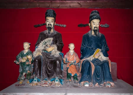 Fengdu, China - May 8, 2010: Ghost City, historic sanctuary. Colorful group statue of Yin and Wang, founders of the religious site, with a tiger under his foot. Red cloth as backdrop.のeditorial素材