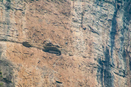 Wuchan, China - May 7, 2010: Dawu or Misty Gorge on Daning River. Ancient hanging coffins of the Ba people set in caves high up on brown cliff walls.の写真素材
