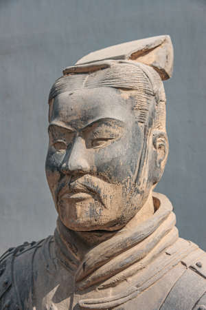 Xian, China - May 1, 2010: Terracotta Army museum. Face closeup of higher officer beige-gray sculpture outside buildiing. Gray wall as backdrop.のeditorial素材