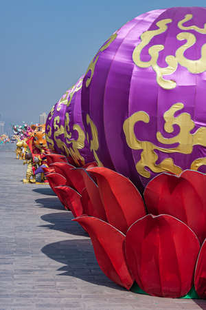 Xian, China - April 30, 2010: North Gate of Huancheng City Wall. Year of the Tiger display. Line of giant purple balls set in red lotus leaves with tiger dolls peeping through. Blue sky.のeditorial素材