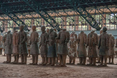Xian, China - May 1, 2010: Terracotta Army museum and hall.  Gray-beige sculptures of falanx of soldiers, some with and some without heads at excavation.のeditorial素材