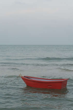 The evening sea during the sunset with red boatの写真素材