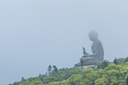 Big Giant Huge Buddha in Hong Kong with the fog cover around area, a place for people and tourist to come and pray and give respect.の写真素材