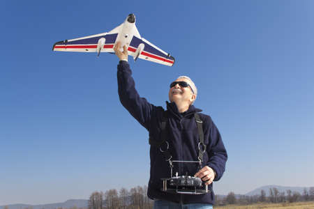 Happy senior RC modeller preparing for launch new remote controlled  planeの写真素材