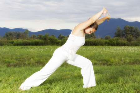 Young attractive brunette girl performing yoga outdoors 
の写真素材