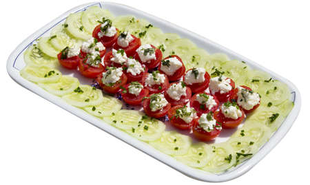 Tasty decoration with fresh organic tomatoes, cucumber, basilica and mozzarella cheese, against whiteの写真素材