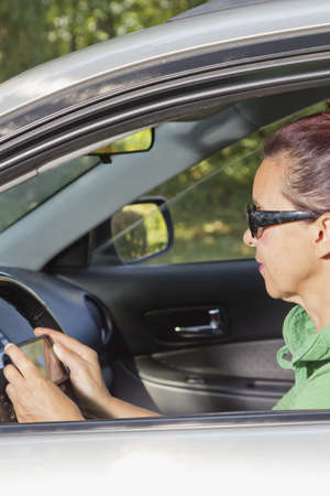 Friendly woman using  tablet phone in the car