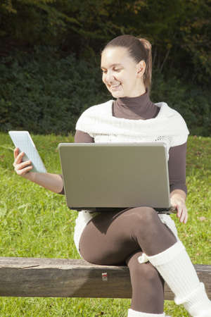 Cute girl in dilemma what to use, bigger, old and heavy notebook or modern tablet PC e-reader