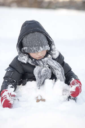 Little kid is playing in deep snow 