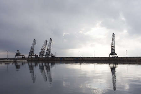 Port cargo cranes before afternoon storm の写真素材
