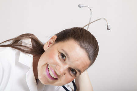 Attractive smiling female doctor playing with her stethoscope の写真素材