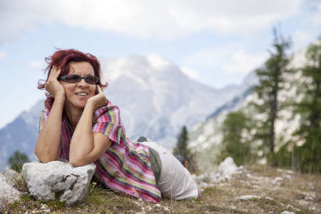 Happy smiling woman hiker resting, lying high in the mountain, selective focusの写真素材
