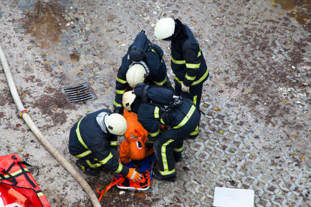 The rescue workers strapping hurt person  dummy  on a stretcher, during  a training exercise  のeditorial素材