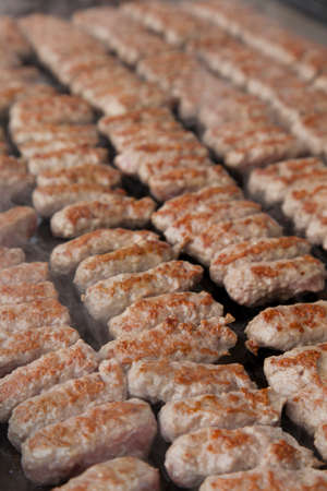 Delicious Balkan cevapi, meat rolls on the smoking BBQ 