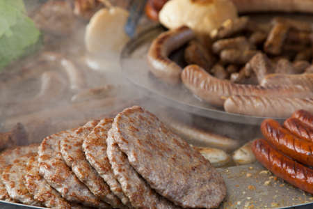 Delicious Balkan cevapi, meat rolls and sausages on the smoking BBQ の写真素材