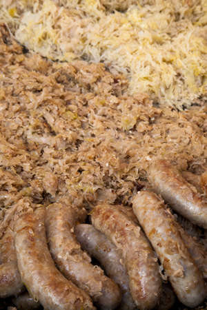 Preparing traditional fried sausages on sauerkraut cabbageの写真素材