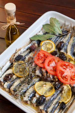 Fresh Mediterranean sardines, mackerel fishes, crispy baked with organic tomato, laurel, rosemary and tasty olives, selective focusの写真素材