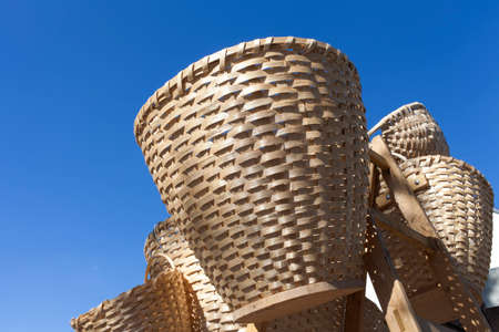 Handmade traditional straw wicker baskets on sunny market,   against blue sky の写真素材