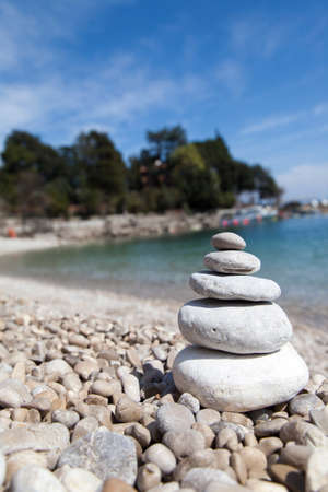 Stack of stones on sandy sea beach against dramatic background, Zen, Feng shui concept, selective focusの写真素材
