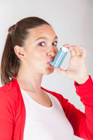 Pretty girl using an asthma inhaler for preventing attacks space for Your textの写真素材