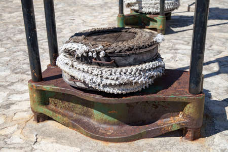 Press for squeezing oil from olives is set on a street in coastal village, ancient olive oil...