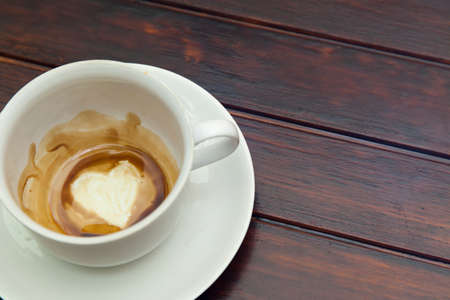 Cup of coffee with Heart of Coffee Grounds, on wooden table, fortunetelling, divination symbol of loveの写真素材
