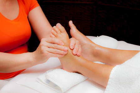 Woman receiving a leg and foot massage while lying on a towel in a award winning health massage center, series of various techniques, glamour clarity effectの写真素材