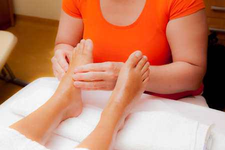 Woman receiving a leg and foot massage while lying on a towel in a award winning health massage center, series of various techniques, glamour clarity effectの写真素材