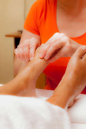 Woman receiving a leg and foot massage while lying on a towel in a award winning health massage center, series of various techniques, glamour clarity effectの写真素材