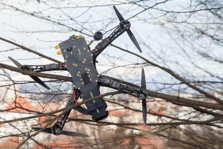 Drone quadcopter accident scene, UAV filming Quadrocopter crashed on tree in city parkの写真素材