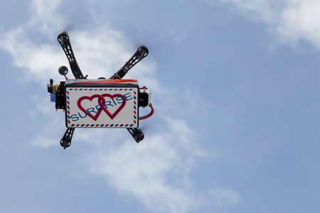UAV drone quadrocopter with modern GPS navigation transporting love surprise in the box, against blue sky, space for textの写真素材