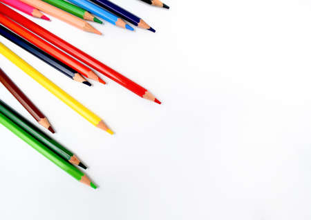 bunch of wax crayons of different colors are scattered randomly on a bright white background