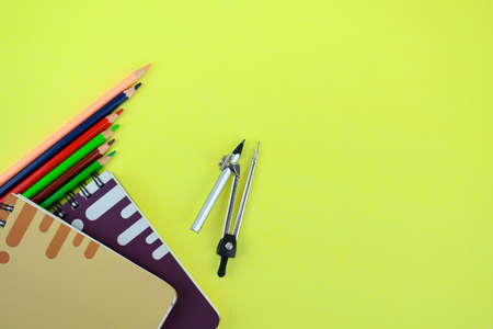 Six wood pencil two note book and a pencil attached to a pencil sharpener scattered on a paper...
