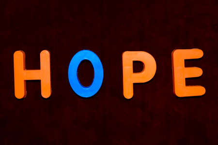 Hope word written with different colored letter blocks arranged on a dark backgroundの写真素材