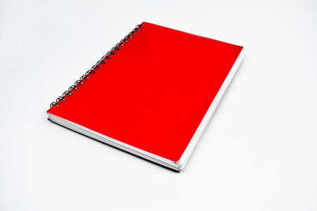 Side view of a red color covered single note paper diary isolated on an empty white backgroundの写真素材