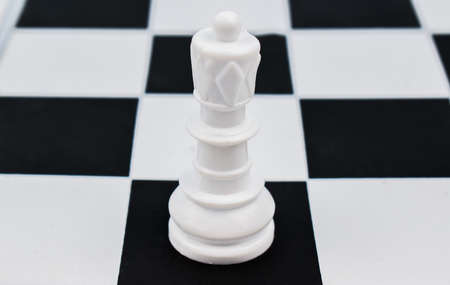 White queen placed on top of a black square of the chess board in a chess game