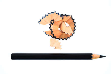 A photograph of some pencil shavings placed beside a black color wood pencil crayonの写真素材