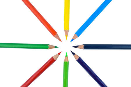 A circle made with eight different colored wood pencil crayon arranged before a white isolated backgroundの写真素材