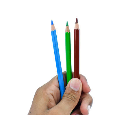 person holding three different color wood pencil crayons with his fingers in his gentle hand