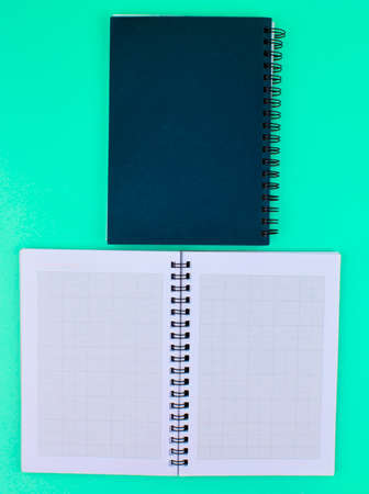 Two note paper diary ,one open and one closed placed beside one another on a blue paper backgroundの写真素材
