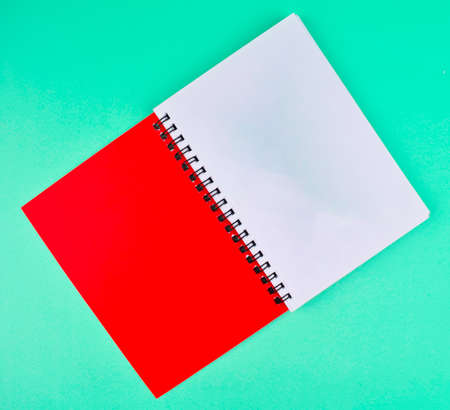 One red colored note paper diary placed on an isolated light blue paper backgroundの写真素材