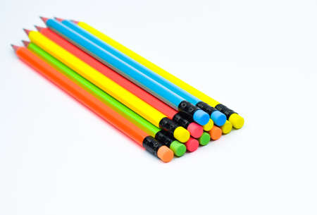 Some different colored wood pencil crayons placed beside one another on white paper background