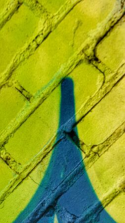 Abstract bright blurry un-focused background pattern texture with bricks running diagonally in green yellow turquoise and with a painting looking similar to the Eiffel tower.の写真素材