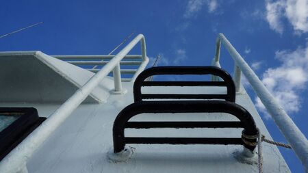 Stairway on ship leading upright direction heaven. conceptual photography of steps on a white boat for the peaceful life or the success in life.の写真素材