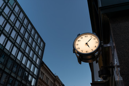 Nighttime in city, large clock in front of storeの写真素材