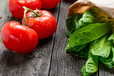 Fresh tomatoes and salad on old grey woodの写真素材