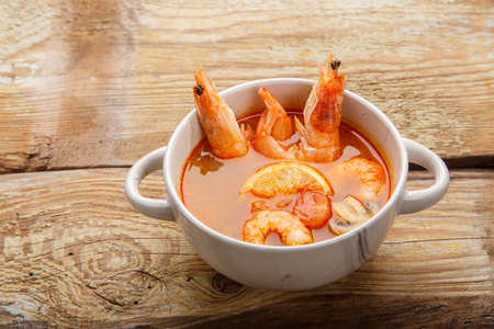 Tom yum soup with shrimps and coconut milk in a tureen.Copy place.の写真素材