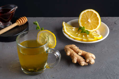 an immune ginger drink with honey and lemon in a glass cup next to the ingredients.の写真素材