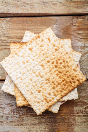 Matza sheets on top of each other lies on a wooden table. Vertical photo